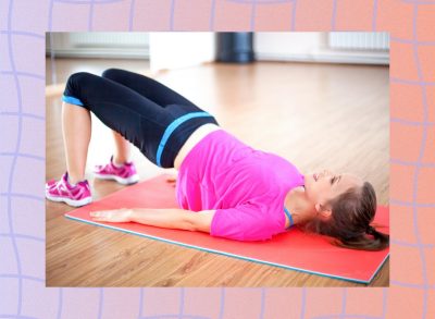 fit brunette woman doing a glute bridge exercise on mat in workout space