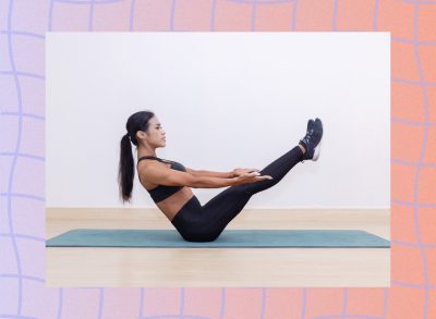 fit, focused woman doing v-sit exercise on yoga mat