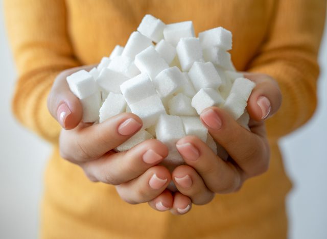 Woman hands holding white sugar cubes