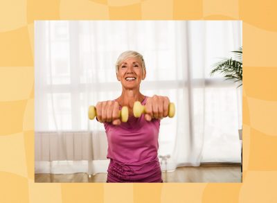 fit, mature woman lifting dumbbells at home in bright living space