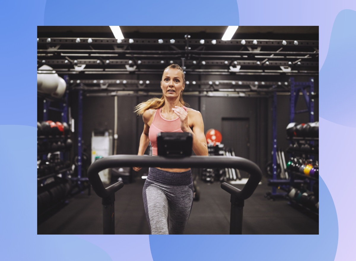 fit woman running on the treadmill in dark gym set-up