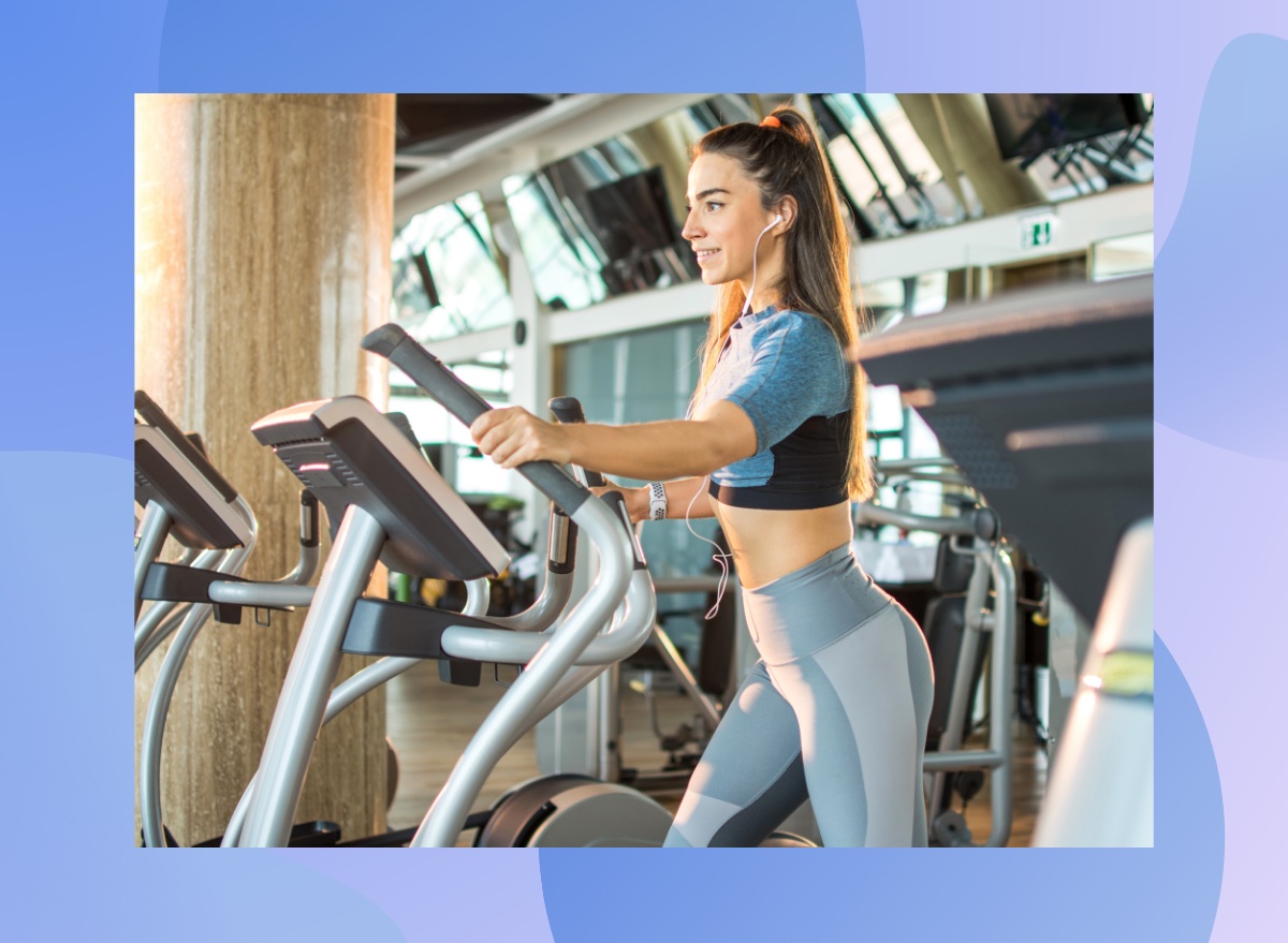 focused brunette woman using elliptical at the gym