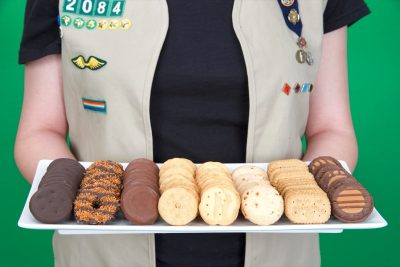 Cadette Girl Scout holding plate of Girl Scout cookies