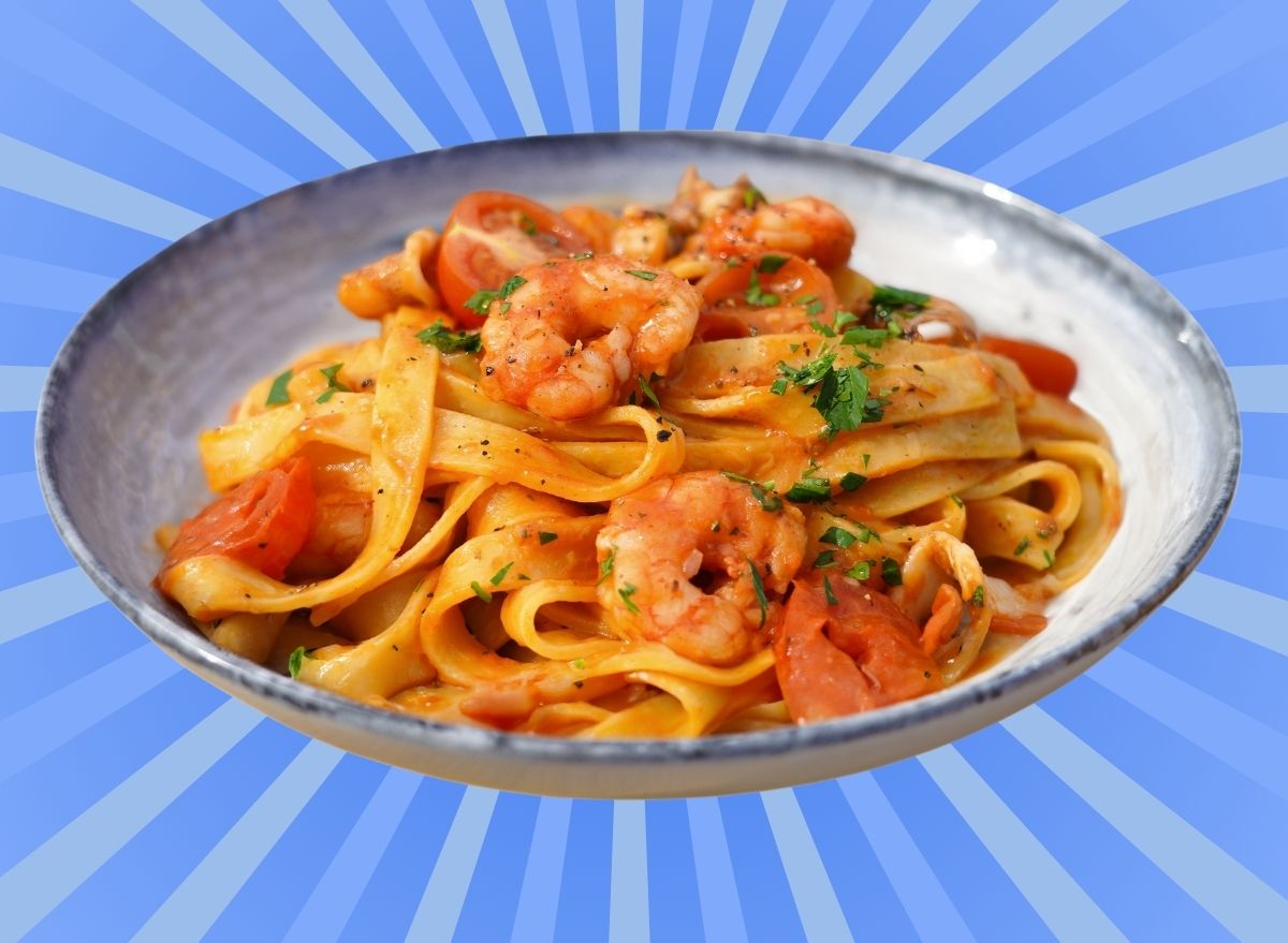 A plate of seafood pasta set against a vibrant background.