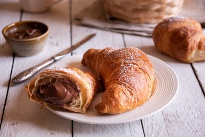 Delicious chocolate croissants fruit for breakfast on rustic wooden table