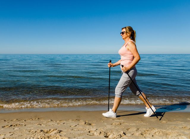 Nordic walking - woman training on beach