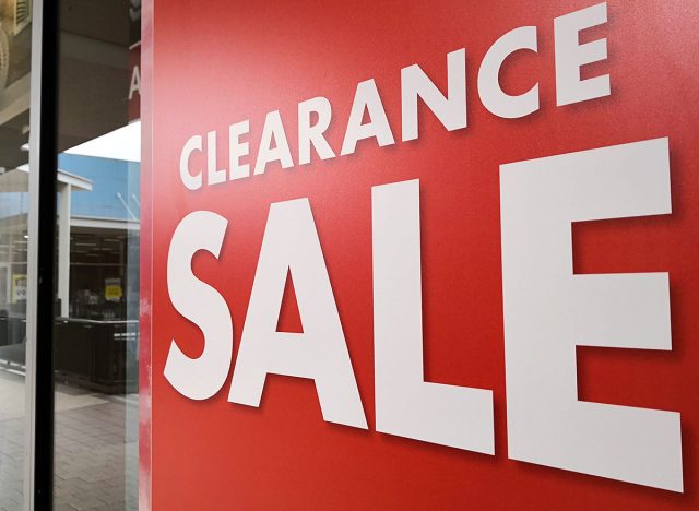 Large Clearance Sale letters on shopping mall window display, bokeh shopping mall as background.