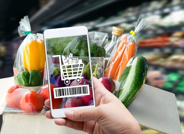 Online order grocery shopping on touch screen concept. Woman hand holding smart phone with checks the bar code or e-wallet on label for ingredient and payment. Business and technology for lifestyle.