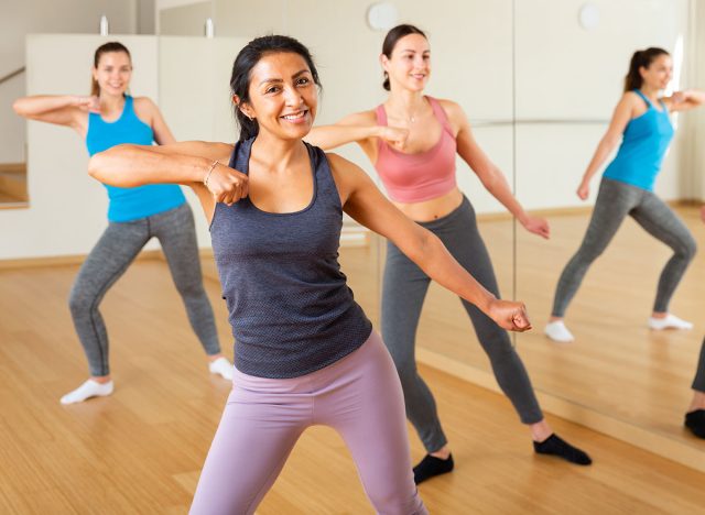 Positive slim athletic women dancing aerobics at lesson in the dance class