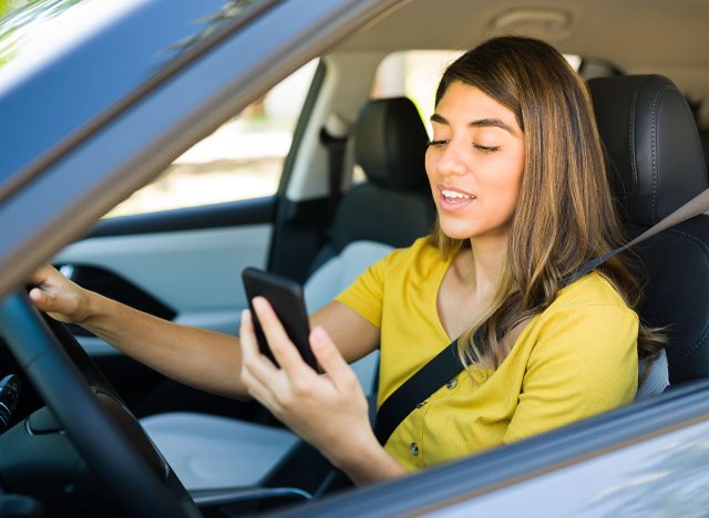 Gorgeous woman driving her car and talking on the phone through a video call while stuck in traffic