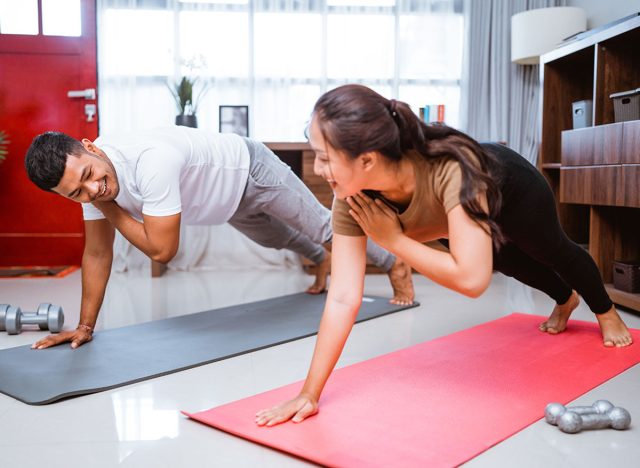 Asian fitness couple planking together. man and woman exercising at home