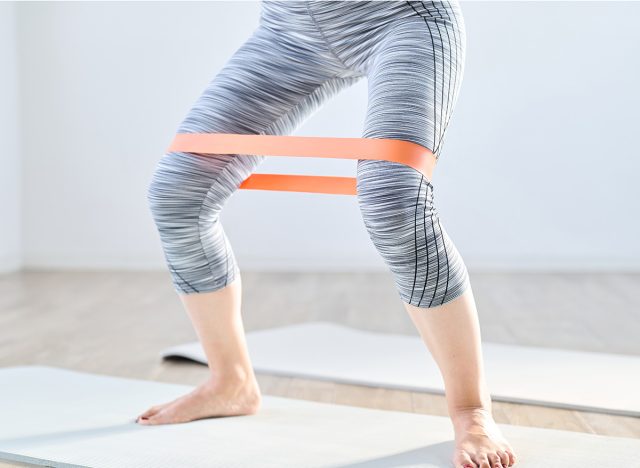 A woman doing lower body training using a resistance band, side step