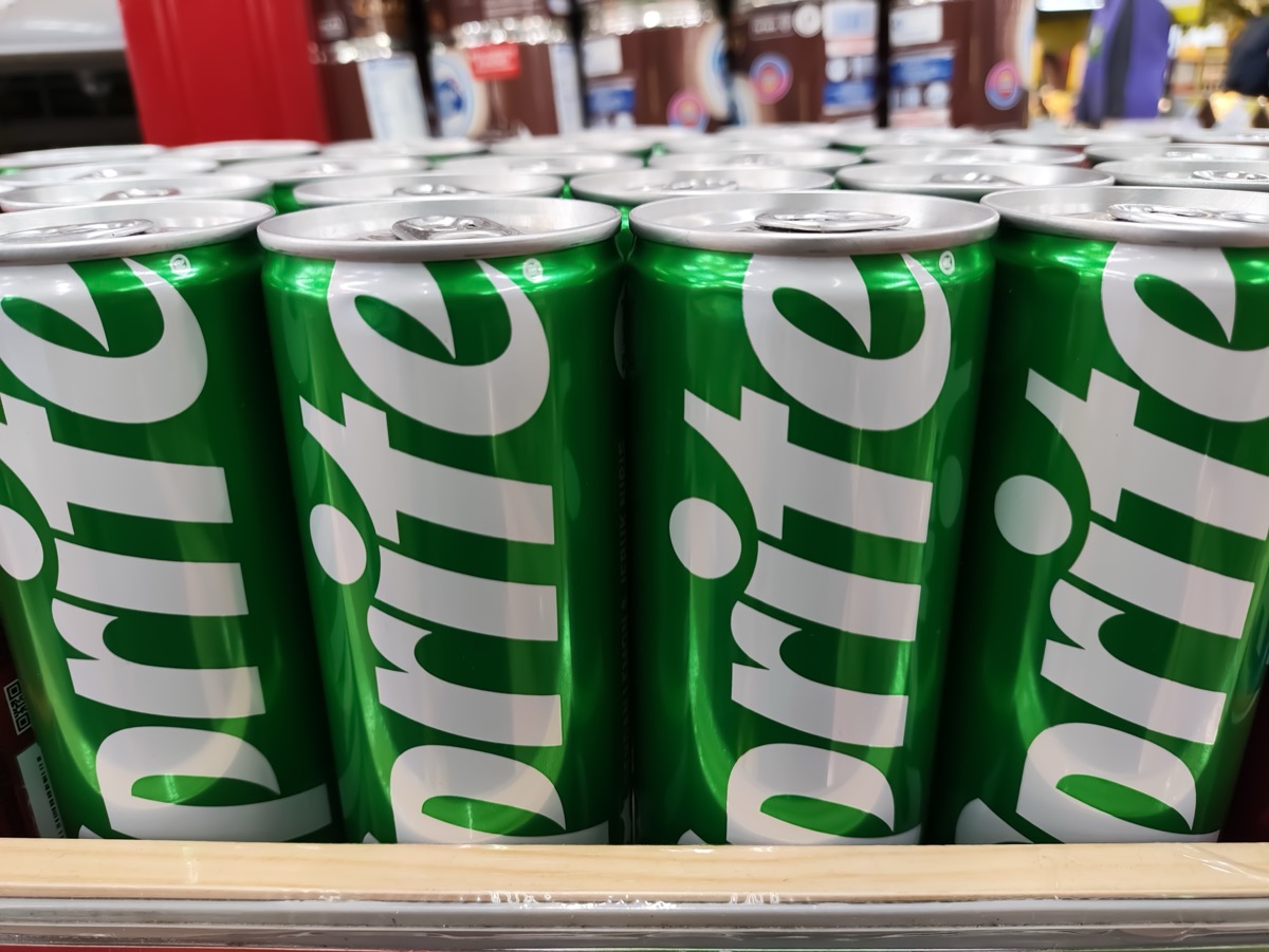 Malang, Indonesia 04-07-2024 : Sprite can in the supermarket. Sprite green can packaging design isolated on supermarket row shelf display background.