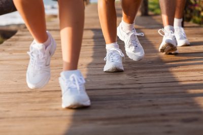 group of people walking on beach for exercising in the morning