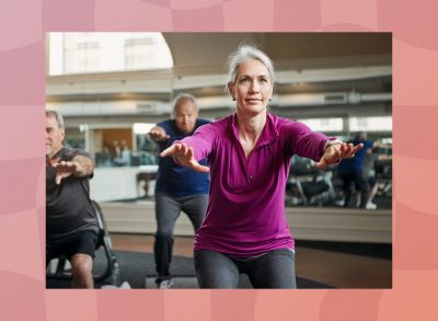 fit, mature woman doing squats in group fitness class at the gym