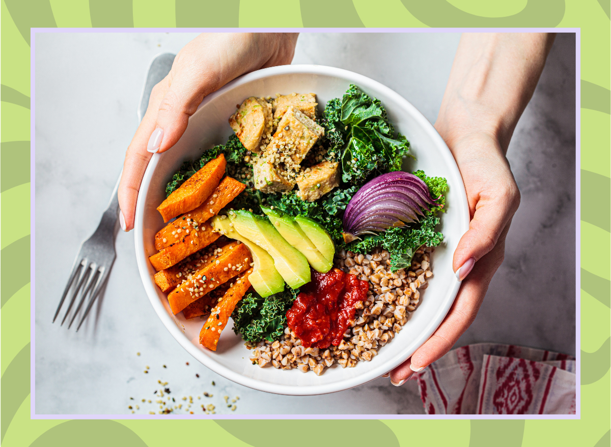 woman holding bowl of vegetables sweet potatoes avocado tofu hemp seeds onion kale grains