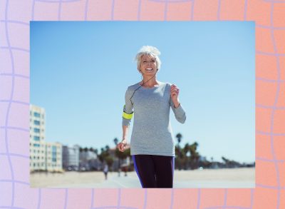 fit, mature woman power walking on the beach on sunny day