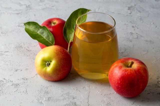 Apple juice in the glass with apples