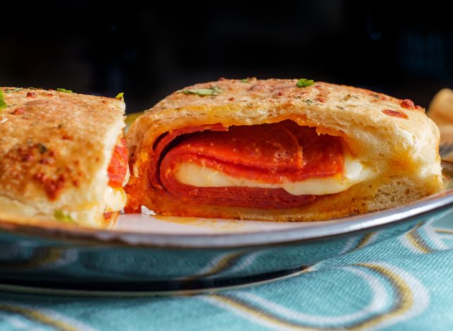 Italian pastry pepperoni and cheese calzone with tomato marinara dipping sauce