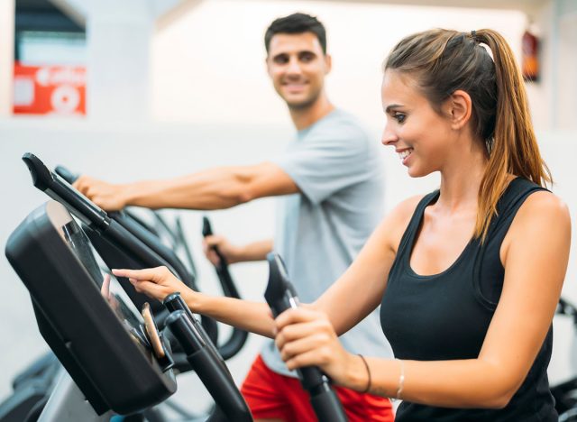 Adult couple is working out on Step climber machine in fitness gym for healthy lifestyle concept.