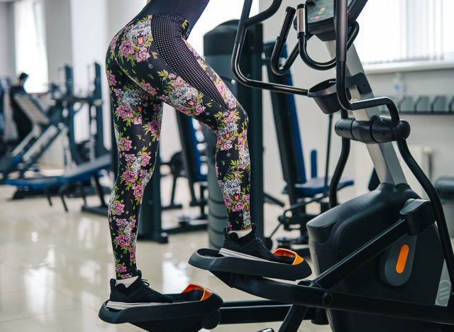 Woman doing legs exercise on stair steppers machine, in gym. selective cropped photo, fit woman. Closeup.