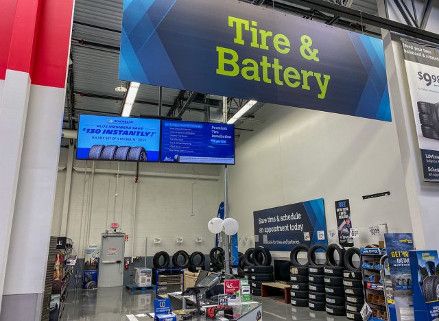 The Tire and Battery aisle of a Sams Club Wholesale retail store with a variety of tires and batteries ready to be purchased by consumers.