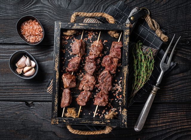 BBQ Beef veal shish kebab Skewers. Black background. Top view.