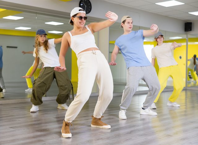 Young girl in sunglasses dancing modern dances in dance studio