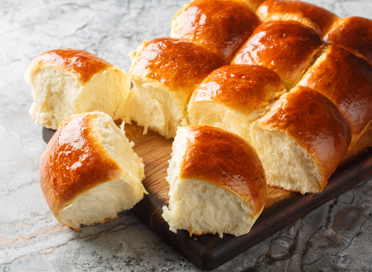 Homemade Baked Sweet Hawaiian Buns Ready to Eat closeup on the wooden board on the table. Horizontal