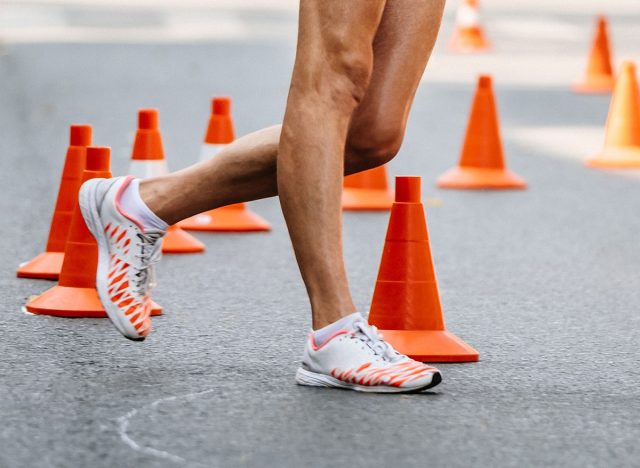 racewalking track, athlete legs, makes a turn around red safety cones