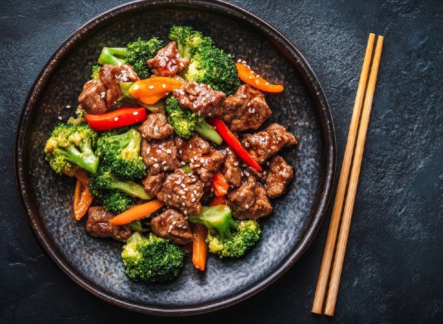 Beef and Broccoli Stir-Fry in Black Bowl on Dark Background