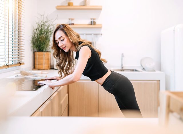 smiling woman doing push up kitchen. gorgeous woman build muscle using home fitness concept push up. happy pretty exerciser relax control exercising position balance healthy body use kitchen counter.