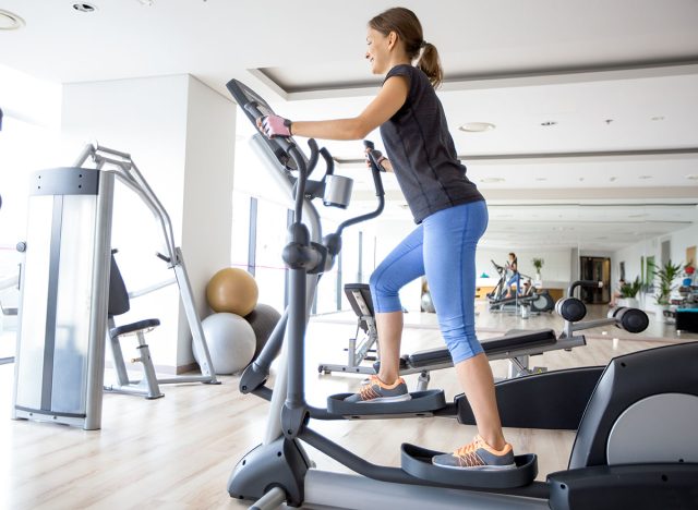 Smiling Girl Training on Stair Stepper in Gym