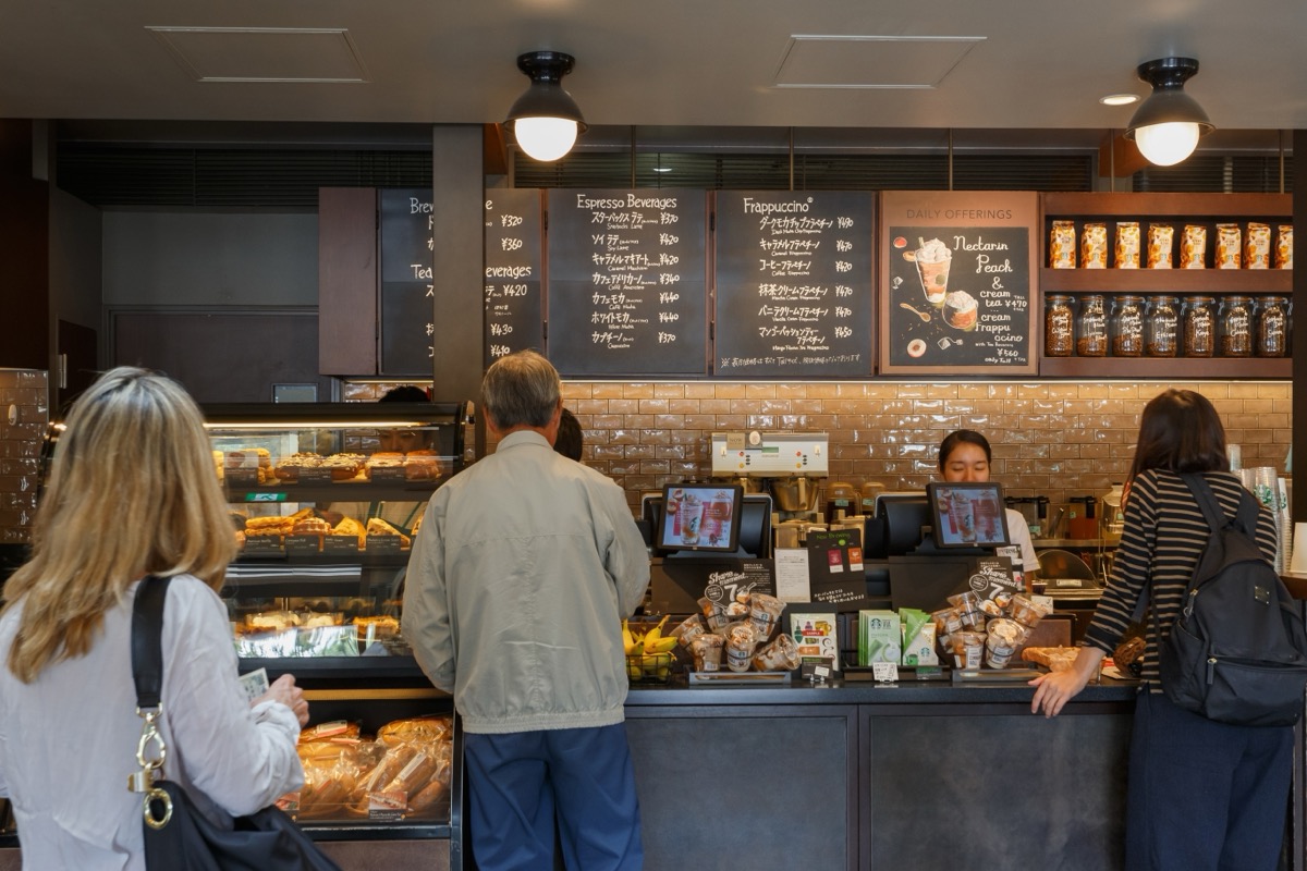 Tokyo, Japan. September 8, 2023 : student working at past time barista at busy morning in coffee shop. Clients order coffee, bread and breakfast in Starbuck coffeeshop before going to work or travel.