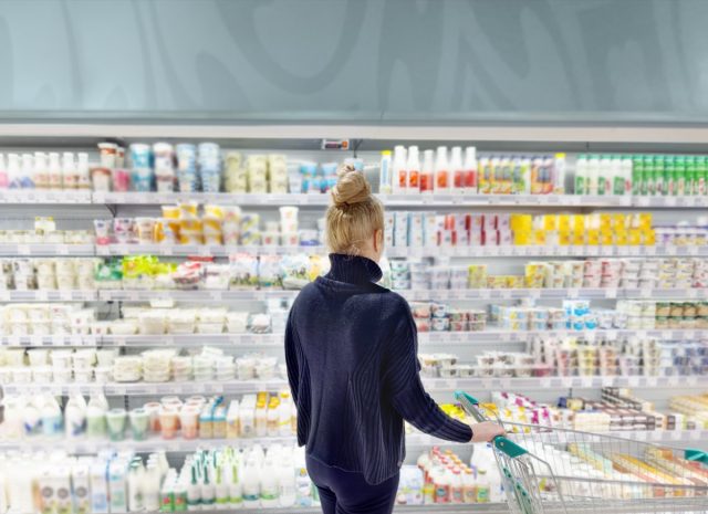 Woman choosing frozen food from a supermarket freezer