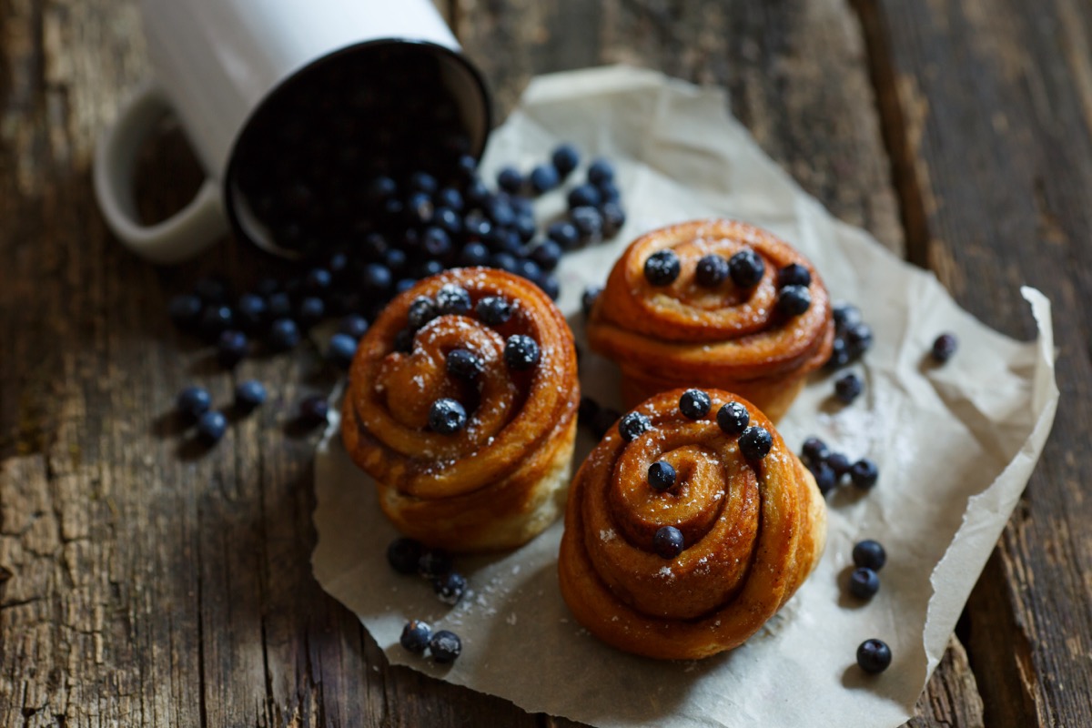 A bun with blueberries on the table. Still life with blueberry baked goods. Background image