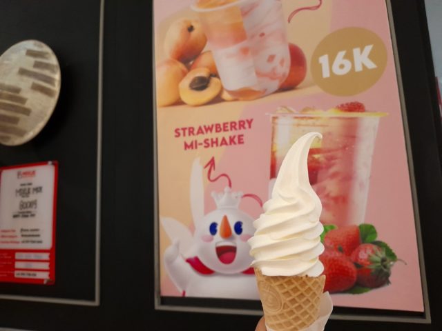 Jakarta, 29 December 2023 : Vanilla ice cream cone with Mixue promotion on the wall.