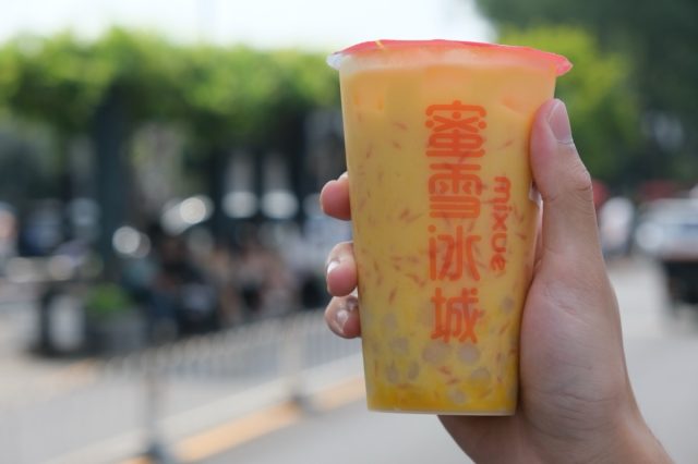 Beijing,China-September 17th 2022: close up hand holding cup of Mixue Bingcheng's drink. A Chinese ice cream and tea brand