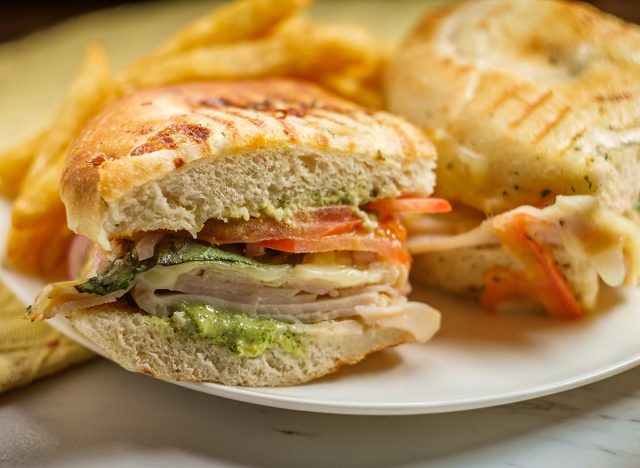 Smoked bistro turkey panini with provolone cheese pesto and tomatoes on focaccia bread