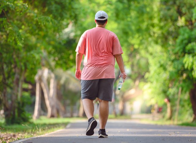 Fat man exercising By walking to burn fat And run slowly to exercise in the park