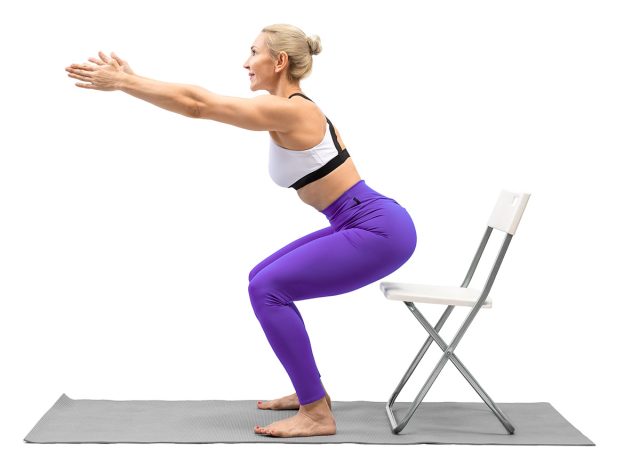 Exercises with props. Athletic caucasian woman in purple leggings practice squats using a chair, isolated on white. Fitness advertising, workout, promotion, sport, training concept. Box squat. 