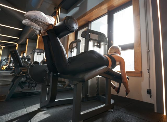 Woman doing hamstring exercise in fitness club 