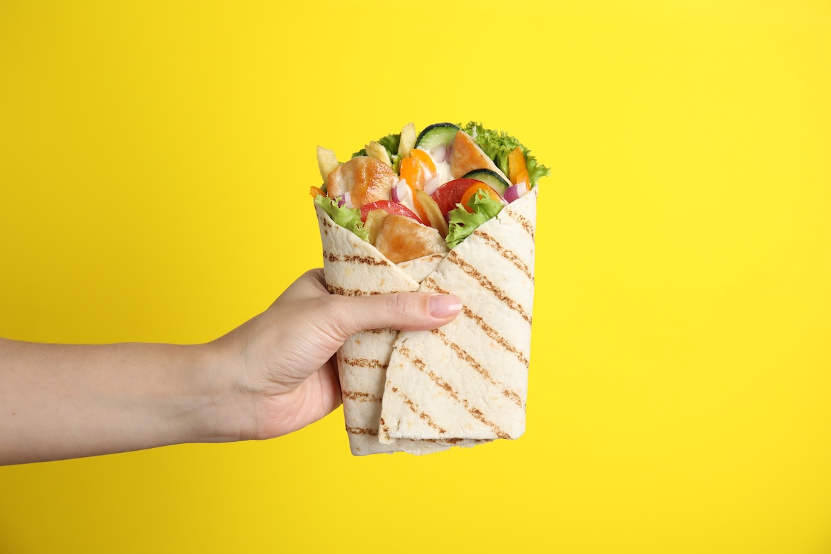 Woman,Holding,Delicious,Chicken,Shawarma,On,Yellow,Background,,Closeup