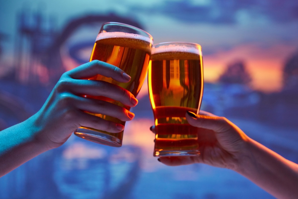 Two,People,Clinking,Beer,Glasses,Against,Vibrant,Sunset,Background,,With