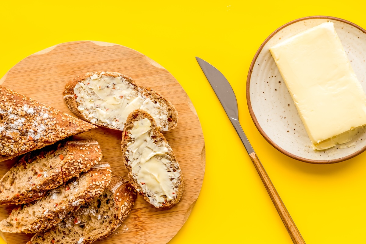 Traditional,Breakfast.,Wholegrain,Bread,On,Cutting,Board,With,Butter,On