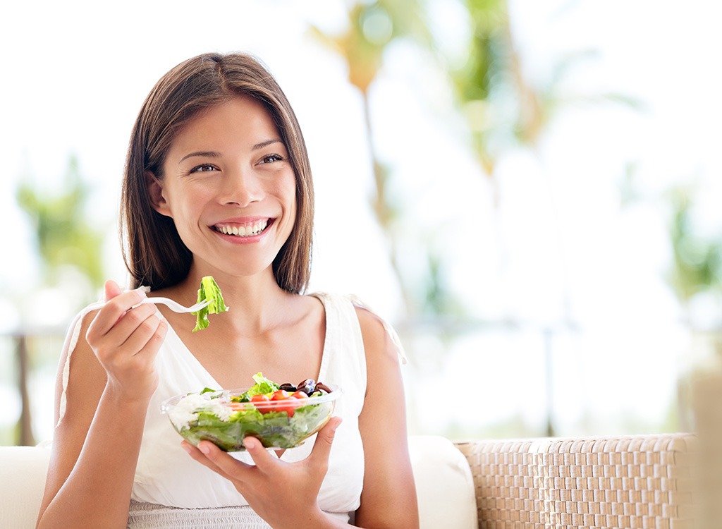woman enjoying a salad - best cheat meal on cheat day